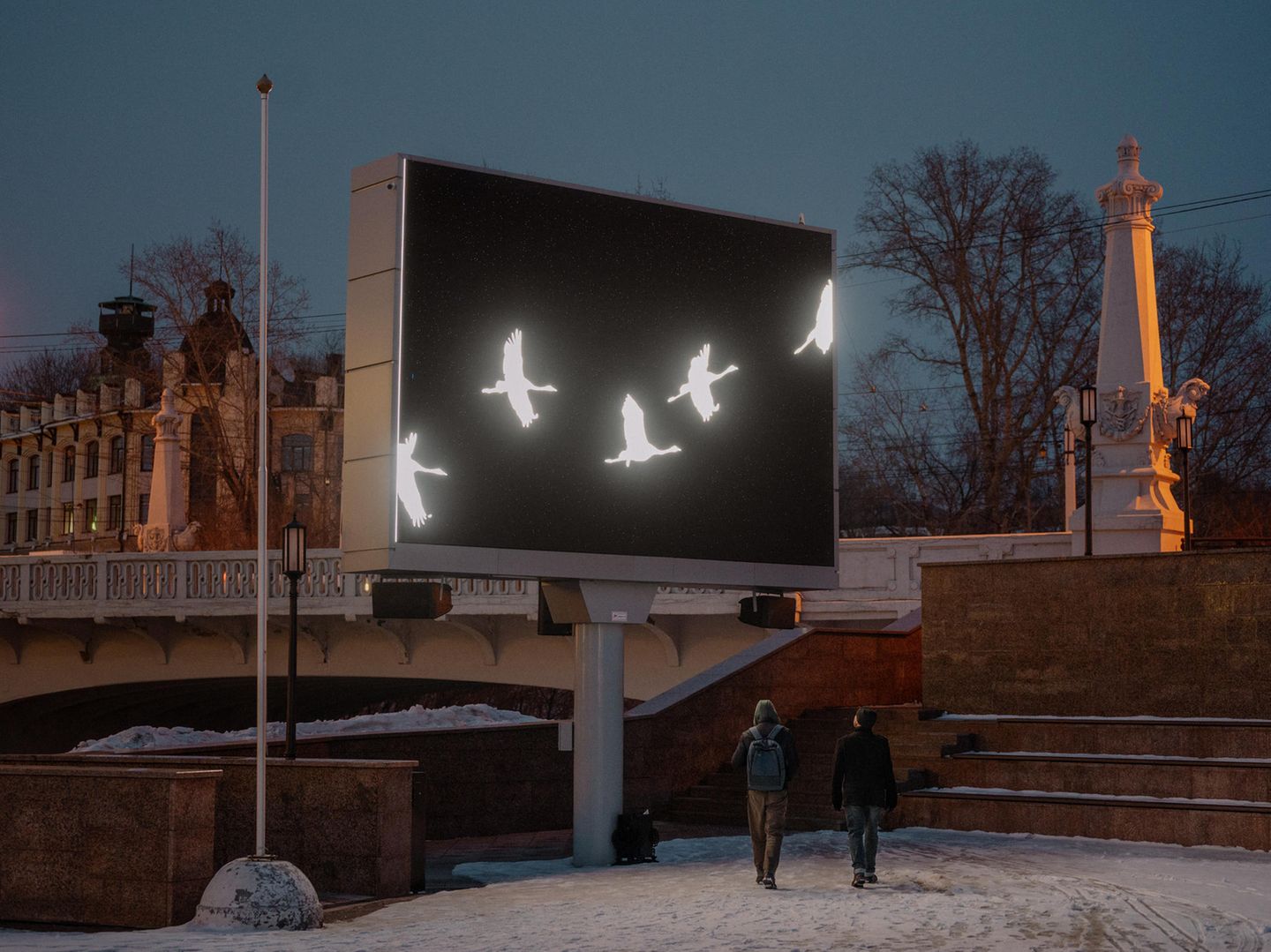 Kraniche auf elektronischen Plakatwänden bei Nacht
