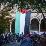 Eine riesige Palästina-Flagge hängt am Gebäude der Universität Barcelona. Im Innenhof haben Studierende ihre Zelte aufgeschlagen.