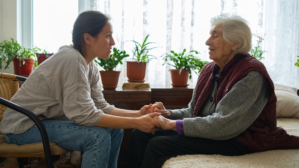 Sorgearbeit: Eine junge und eine ältere Frau halten sich an den Händen
