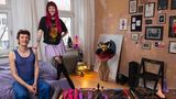 Junges Paar posiert in ihrer eigenen Wohnung vor ihrer Sammlung von Sexspielzeugen
