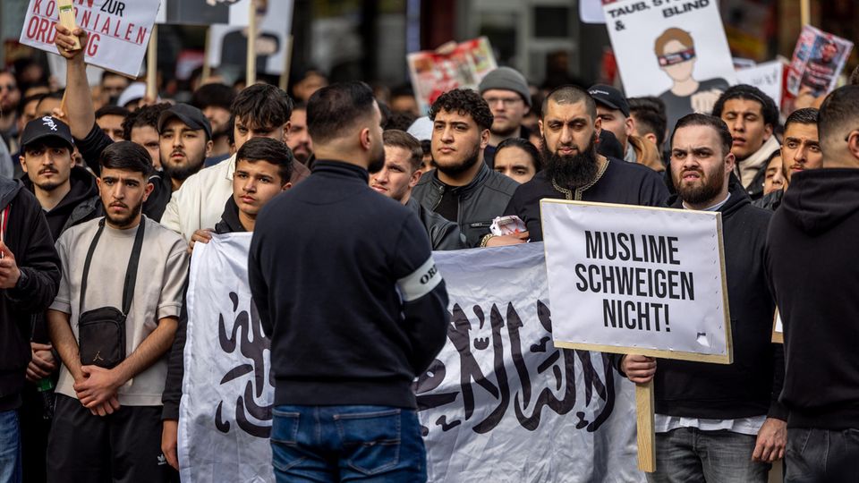 Männer prangern bei der Islamisten-Demo in Hamburg die aus ihrer Sicht islamfeindliche Politik in Deutschland an