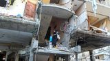 Eine Frau in einem zerstörten Haus in Palästina