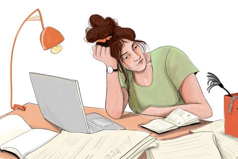 Eine Frau sitzt am Tisch und schaut eine Schachtel mit Sexspielzeug an.