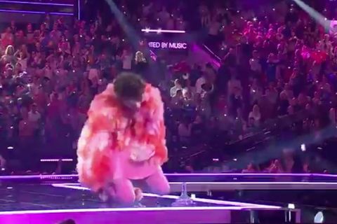 Nemo kniet auf der ESC-Bühne neben dem abgebrochenen Pokal