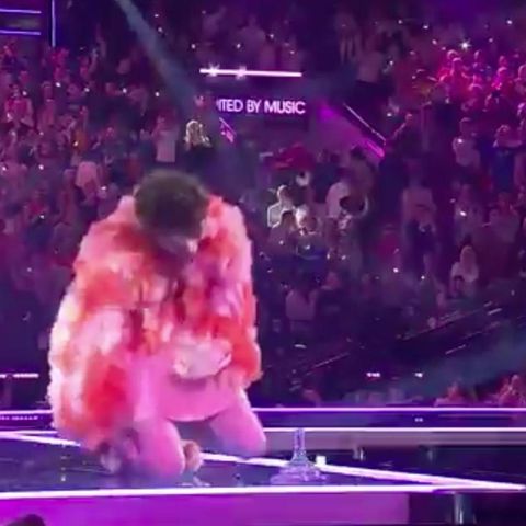 Nemo kniet auf der ESC-Bühne neben dem abgebrochenen Pokal