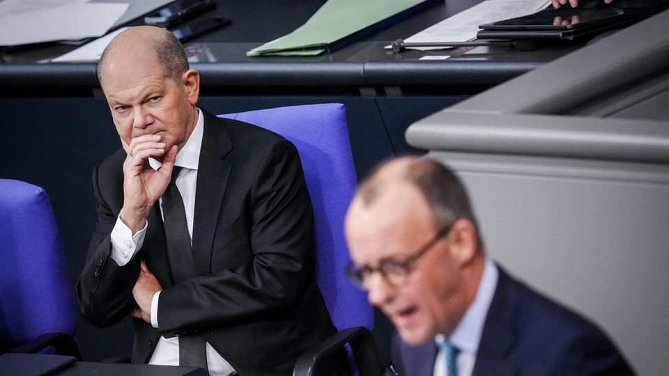 Friedrich Merz (CDU) spricht neben Bundeskanzler Olaf Scholz (l, SPD) im Bundestag
