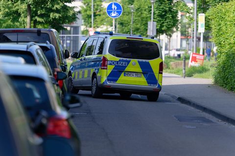 Ein Polizeiauto steht in einer Straße am Rand des Bürgerparks in Köln-Kalk