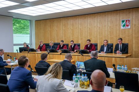 AfD-Politiker und -Anwälte sitzen vor den Richtern des Oberverwaltungsgerichts Münster