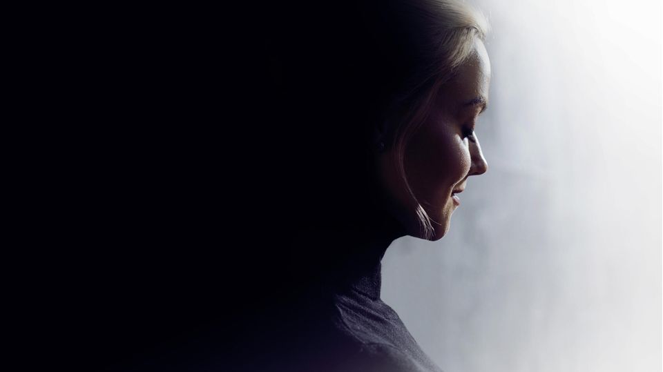 Unterbewusstsein: Profil einer jungen Frau, deren Gesicht im Licht ist, während ihr Hinterkopf mit Dunkelheit verschmilzt