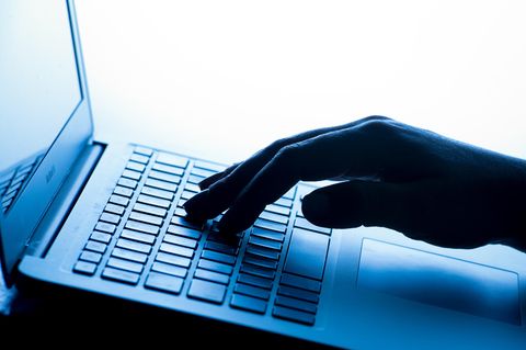 Eine Hand tippt auf einem Laptop – Cyberkriminalität