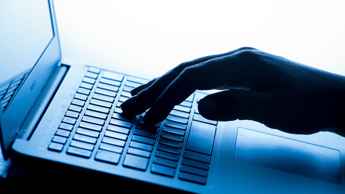 Eine Hand tippt auf einem Laptop – Cyberkriminalität
