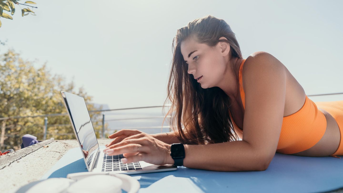 Dropshipping: Junge Frau arbeitet am Laptop in der Nähe des Meeres