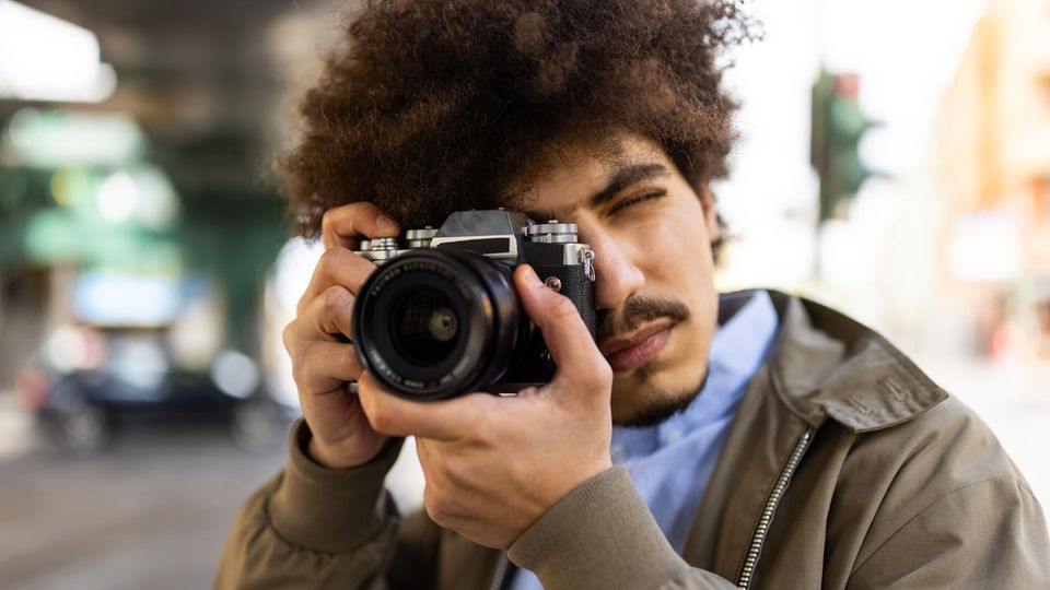 Deals und Angebote: Junger Fotograf mit einer Digitalkamera