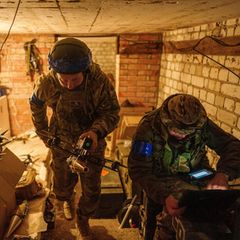 Ein ukrainischer Soldat trägt eine Selbstmord-FPV-Drohne in die Startposition