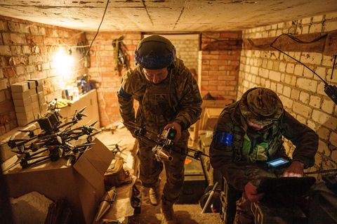 Ein ukrainischer Soldat trägt eine Selbstmord-FPV-Drohne in die Startposition