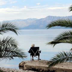 Rente: Ein Rentner am Palmenstrand in Kroatien