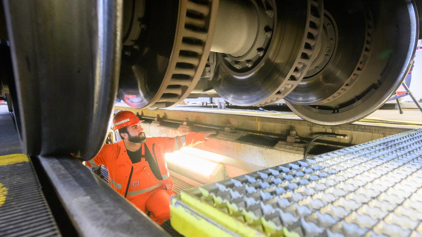Platz 12: Deutsche Bahn Bahn-Facharbeiter steht unter einem ICE und prüft die Räder
