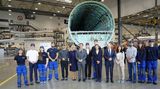 Auszubildende posieren zusammen mit Scholz und Macron im Airbus-Werk in Hamburg-Finkenwerder