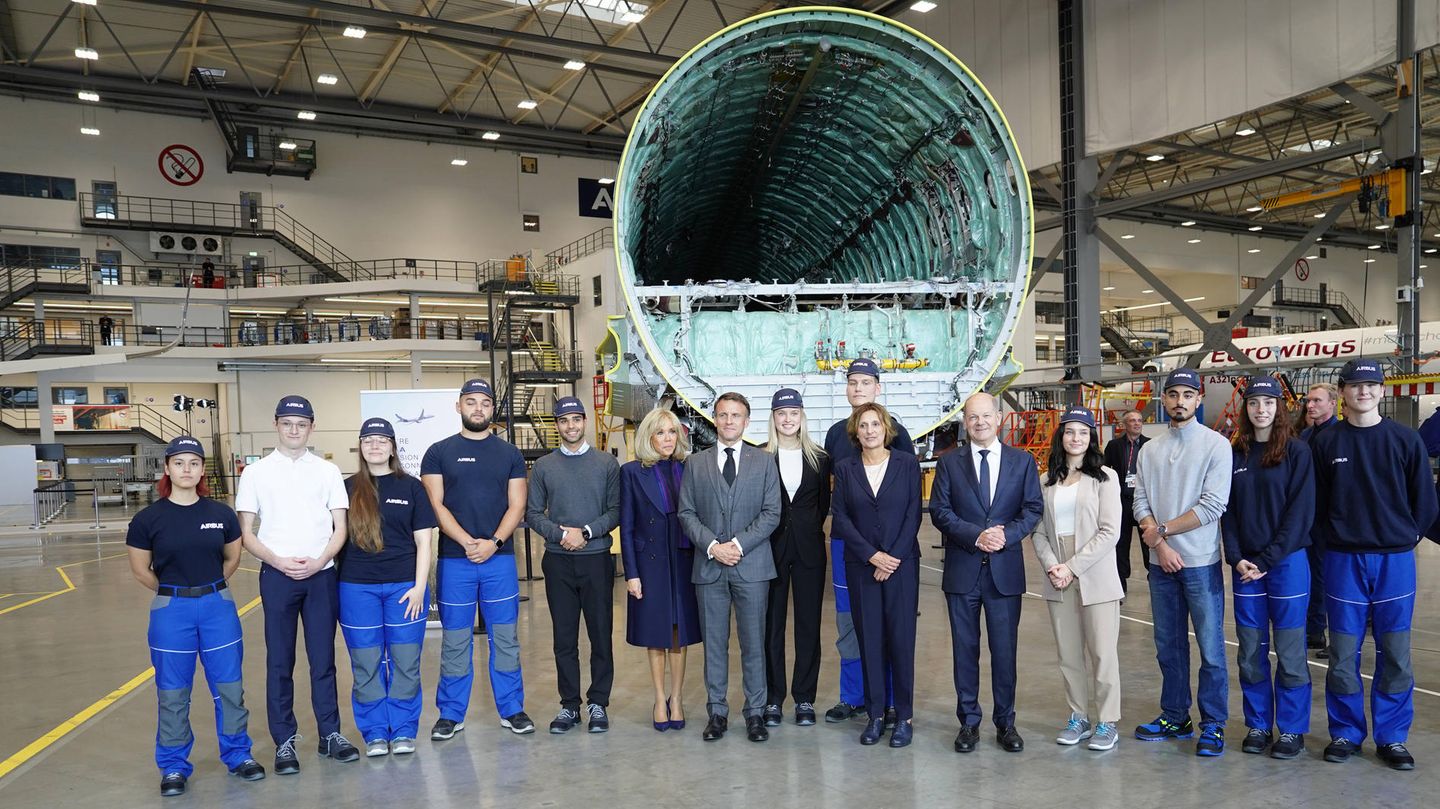 Platz 9: Airbus Auszubildende posieren zusammen mit Scholz und Macron im Airbus-Werk in Hamburg-Finkenwerder