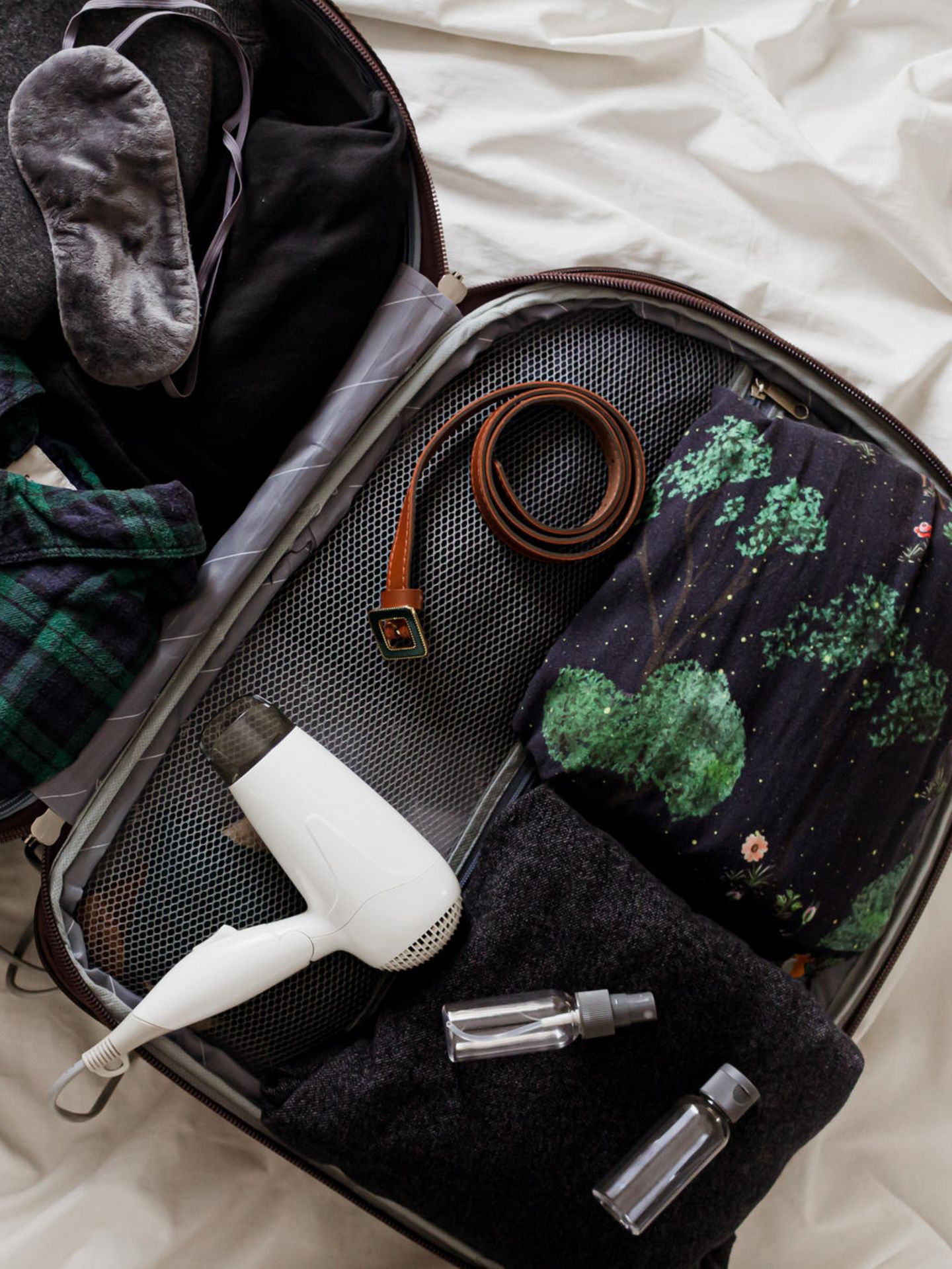 Ein Reiseföhn liegt in einem Koffer