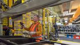 Amazon-Beschäftigte scannt Produkte im Warenlager ein