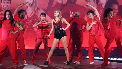 Taylor Swift und ihre Tänzer stehen auf einer in Rot gehüllten Bühne