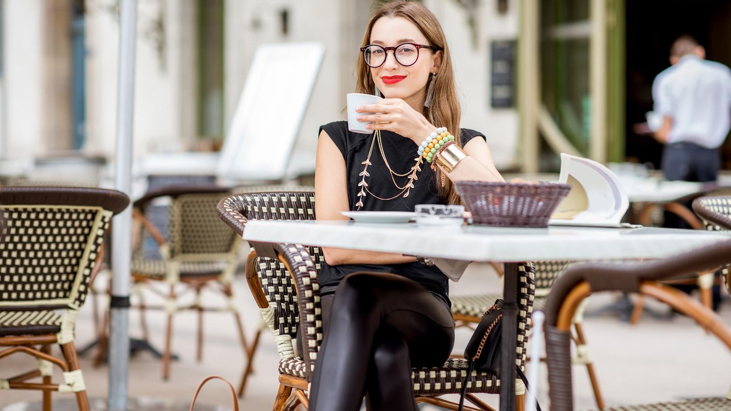 Eine Frau trinkt einen Kaffee in Paris
