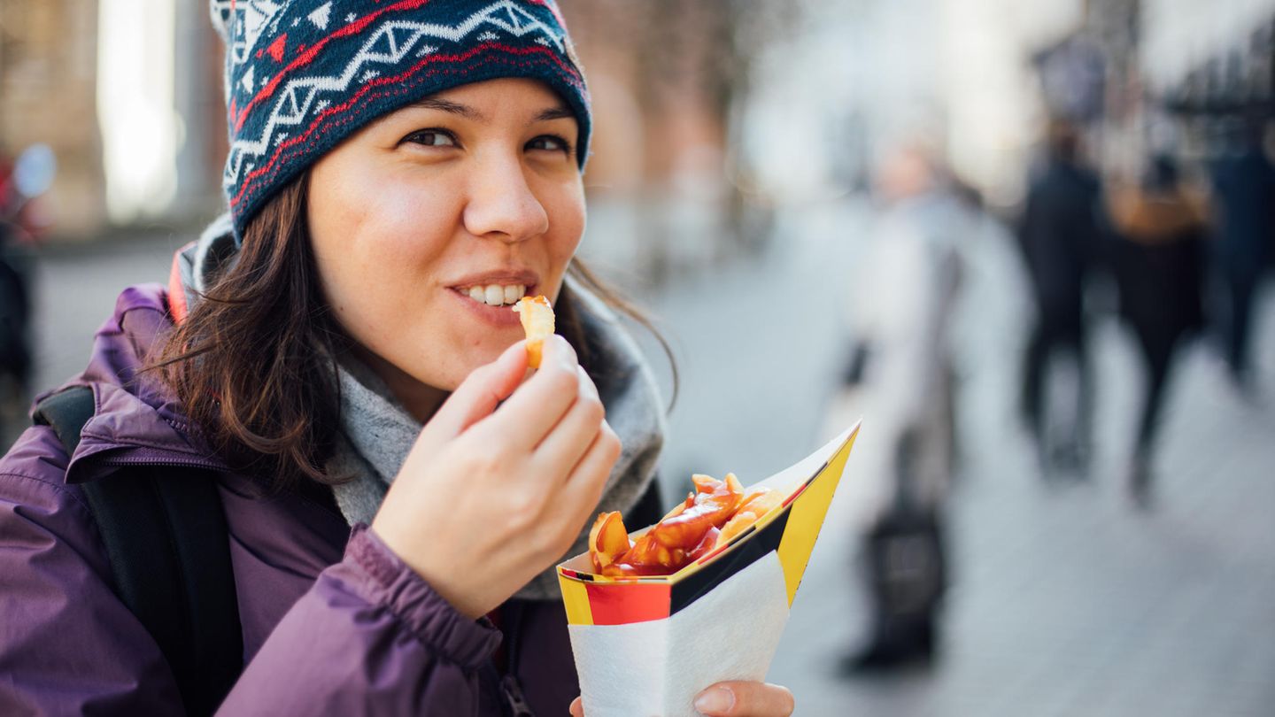 Eine Frau isst Pommes frites
