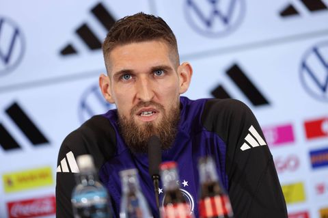Robert Andrich sitzt auf einer Pressekonferenz des DFB und spricht in ein Mikrofon
