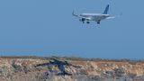 Ein Flugzeug wirft beim Anfluf auf Kreta einen Schatten auf einem Felsen