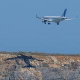 Ein Flugzeug wirft beim Anfluf auf Kreta einen Schatten auf einem Felsen