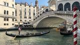 Eine Gondel unter einer Brücke in Venedig