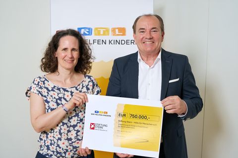 Vertreter der RTL- und stern-Stiftung halten einen Scheck über 750.000 Euro