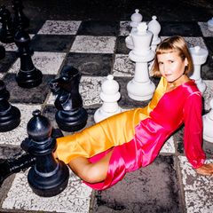 Caroline Wahl sitzt auf einem großen Schachbrett