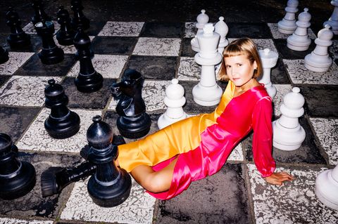 Caroline Wahl sitzt auf einem großen Schachbrett