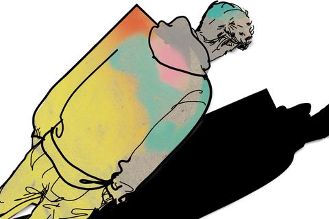 Ein junger Mann steht schräg mit dem Rücken zu uns. Eine Schulter ist eckig.
