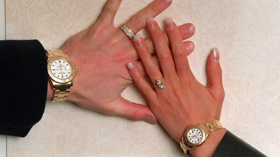 two hands with diamond rings and gold watches two hands with diamond rings and gold watches