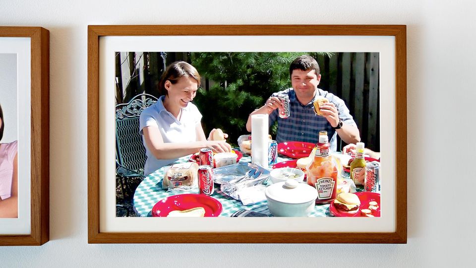 Ein Foto von Cindy und Rick beim Frühstück in einer Bilderrahmen an der Wand