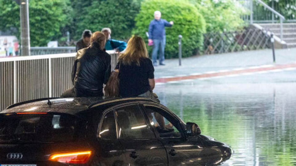 Schwere Unwetter wüten seit den Abendstunden in der Innenstadt von Nürnberg. Hier hat sich ein Paar vor den Wassermassen auf das Dach ihres Autos geflüchtet.