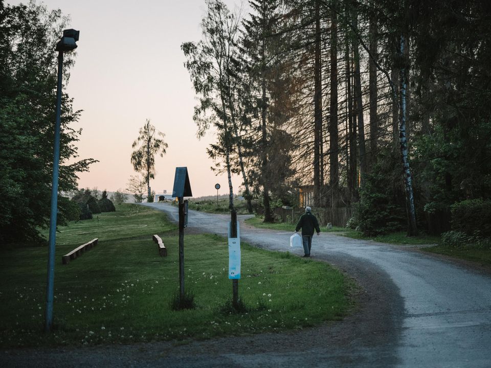 Horst Rieche trägt in der Morgendämmerung einen zugedeckten Käfig zum Wettbewerb Horst Rieche trägt in der Morgendämmerung einen zugedeckten Käfig zum Wettbewerb