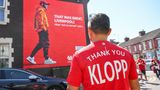 Alles im Zeichen des Abschieds: Ein Fan trägt unweit der Anfield Road ein Danke-Shirt für Jürgen Klopp. Auf der Hauswand auf der Gegenseite ist ebenfalls Klopp zu sehen und die Aufschrift "Das war großartig, Liverpool. Neun 'nicht so normale' Jahre". "Nicht so normal" ist eine Anspielung auf Klopps erste Pressekonferenz im Oktober 2015, als er sich als "the normal one" der Presse vorstellte.