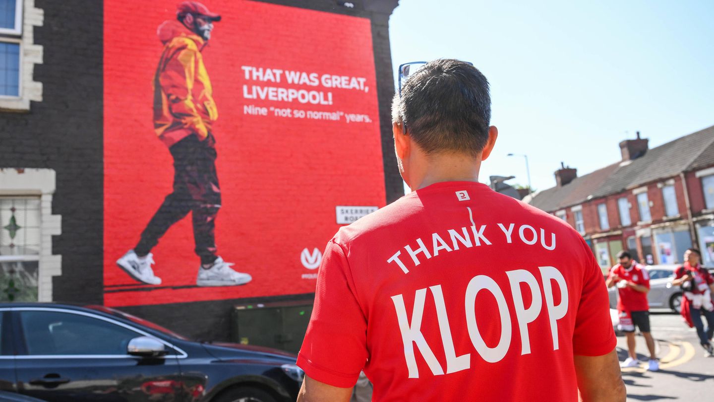 Alles im Zeichen des Abschieds: Ein Fan trägt unweit der Anfield Road ein Danke-Shirt für Jürgen Klopp. Auf der Hauswand auf der Gegenseite ist ebenfalls Klopp zu sehen und die Aufschrift "Das war großartig, Liverpool. Neun 'nicht so normale' Jahre". "Nicht so normal" ist eine Anspielung auf Klopps erste Pressekonferenz im Oktober 2015, als er sich als "the normal one" der Presse vorstellte.