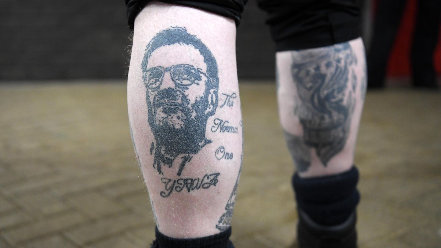 Abschied aus England: Eine Liebe, die unter die Haut geht: Klopp ist auch auf den Beinen und anderen Körperteilen von Liverpool-Fans verewigt. Dieses Tattoo ziert den Verweis auf Klopps Spitznamen "The normal one" sowie "YNWA" – der Stadionhymne "You'll never walk alone", die vor jeder Partie an der Anfield Road gesungen wird. Eine Liebe, die unter die Haut geht: Klopp ist auch auf den Beinen und anderen Körperteilen von Liverpool-Fans verewigt. Dieses Tattoo ziert den Verweis auf Klopps Spitznamen "The normal one" sowie "YNWA" – der Stadionhymne "You'll never walk alone", die vor jeder Partie an der Anfield Road gesungen wird.