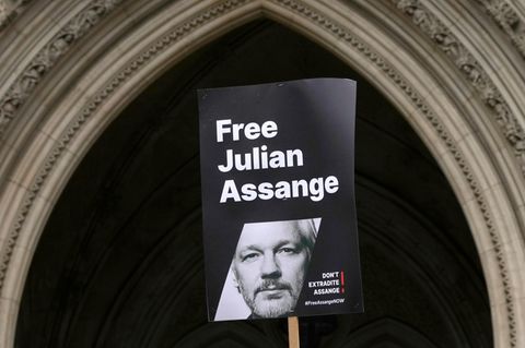 Ein Transparent mit dem Konterfei von Julian Assange wird vor dem Royal Courts of Justice in London hochgehalten