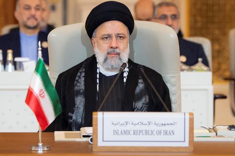 Ebrahim Raisi sitzt mit schwarzem Turban und Mantel bei einer Konferenz der Arabischen Liga