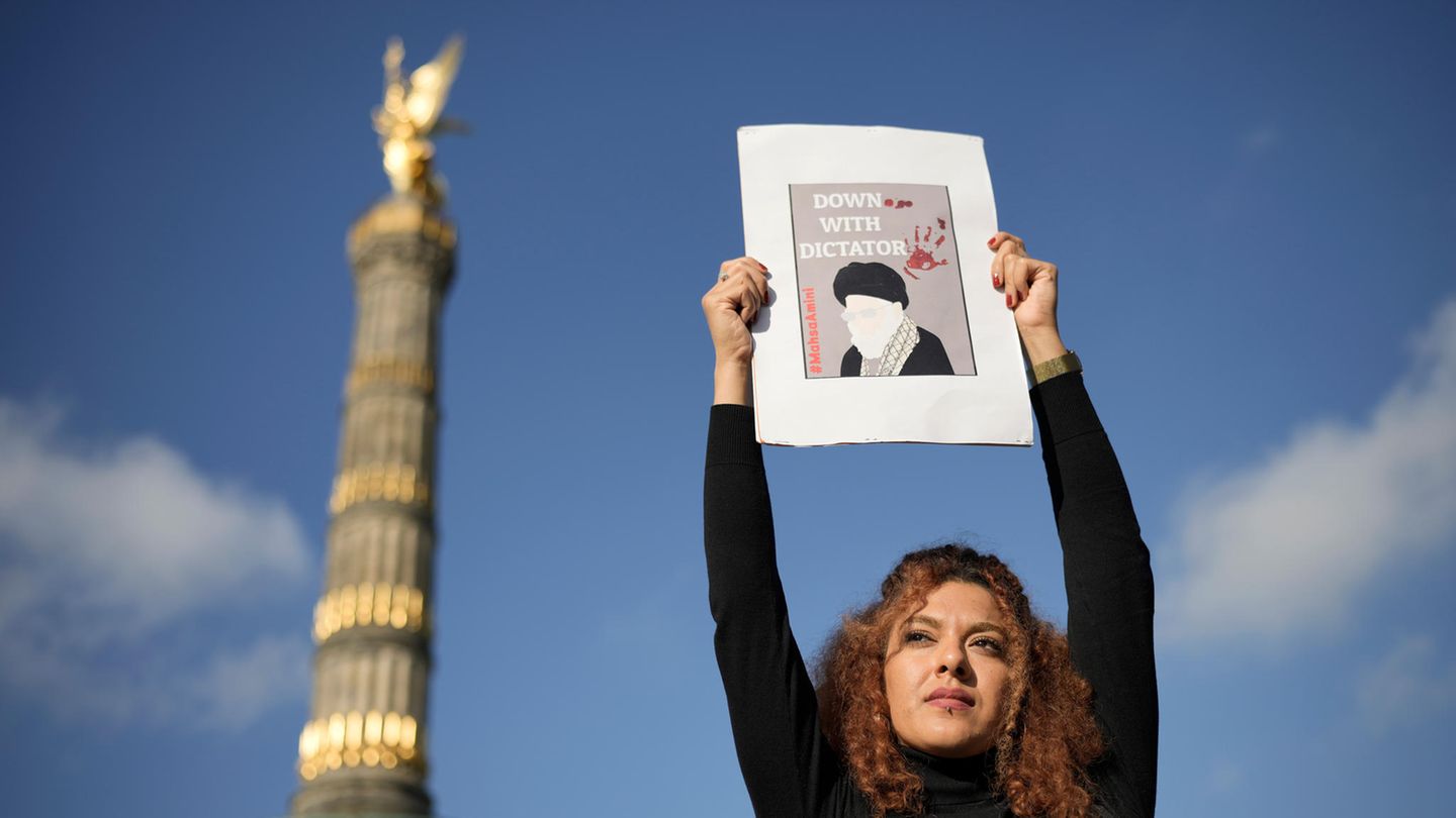 Eine Frau in Berlin protestiert mit einem Bild gegen Raisi in Berlin, Oktober 2022