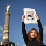 Eine Frau in Berlin protestiert mit einem Bild gegen Raisi in Berlin, Oktober 2022