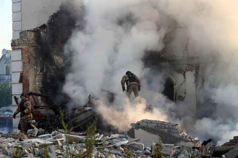 Feuerwehrleute versuchen einen Brand in einem zerstörten Gebäude in Charkiw zu löschen