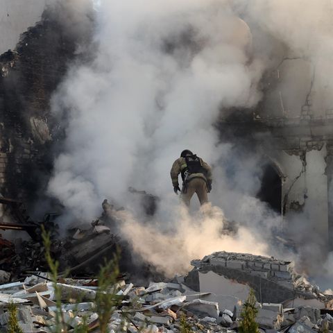 Feuerwehrleute versuchen einen Brand in einem zerstörten Gebäude in Charkiw zu löschen