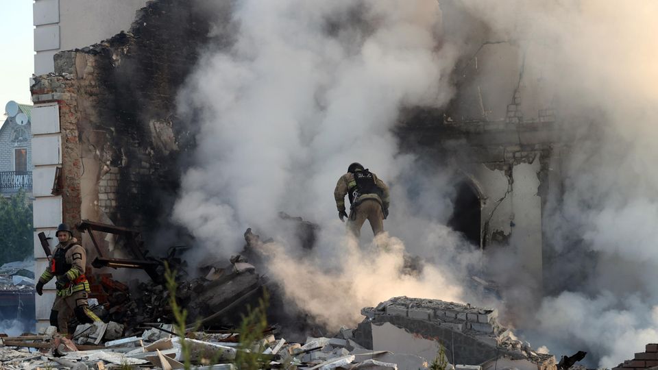 Feuerwehrleute versuchen, einen Brand in einem zerstörten Gebäude in Charkiw zu löschen